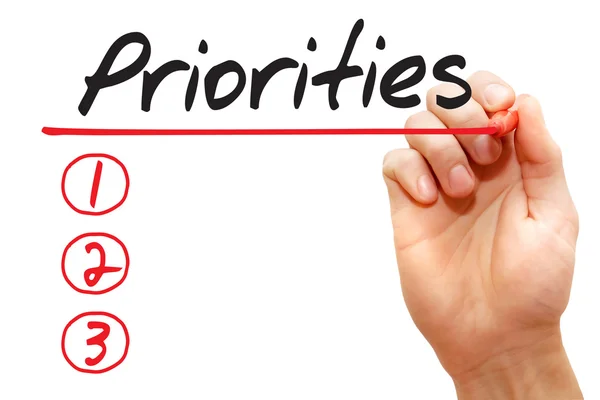 Hand skriva prioriteringar listan, business begreppsmässigt — Stockfoto