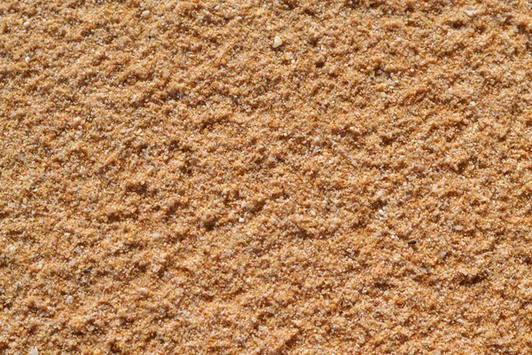 Sahilde sarı deniz kumu. Yakın çekim. Üst manzara, arka plan için yüzey.