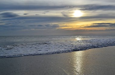 Güzel bir gün batımı Denizde bulutlar, gümüş ve turuncu renkler