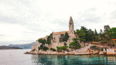 Dubrovnik yakınlarındaki Lopud Adası 'ndaki kilise manzarası. Lopud adasındaki kilise ve kuleye insan olmadan tekneden bakmak.