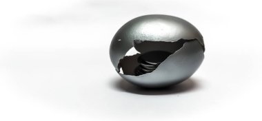 Emeklilik parası, tasarruf, finans, yatırım, sabit mevduat kavramını sembolize eden seçici odaklı, beyaz arka planda izole edilmiş bozuk paralarla Gümüş Yumurta Kabuğu 'nun kapanışı