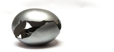 Emeklilik parası, tasarruf, finans, yatırım, sabit mevduat kavramını sembolize eden seçici odaklı, beyaz arka planda izole edilmiş bozuk paralarla Gümüş Yumurta Kabuğu 'nun kapanışı