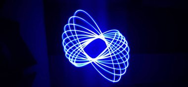 Siyah arka planda izole edilmiş Neon mavisi Spirograph geometrik desene yakın çekim. Hafif boyama tekniği ile yapılmış, uzun pozlama. Sarkaç deseni. Işık yolları. Dalgalar. Işınlar. Çakra. Mandela. 