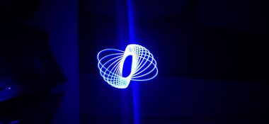 Siyah arka planda izole edilmiş Neon mavisi Spirograph geometrik desene yakın çekim. Hafif boyama tekniği ile yapılmış, uzun pozlama. Sarkaç deseni. Işık yolları. Dalgalar. Işınlar. Çakra. Mandela. 