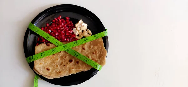 Ketogenic Diet, Plate of Chapathi, pomegranate and Nuts a complete composition of healthy Balanced diet. Isolated background with selective focus and copy space.