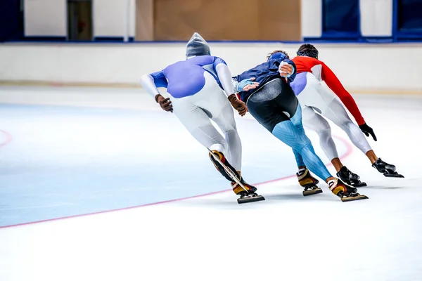 three athletes skating on ice sports arena