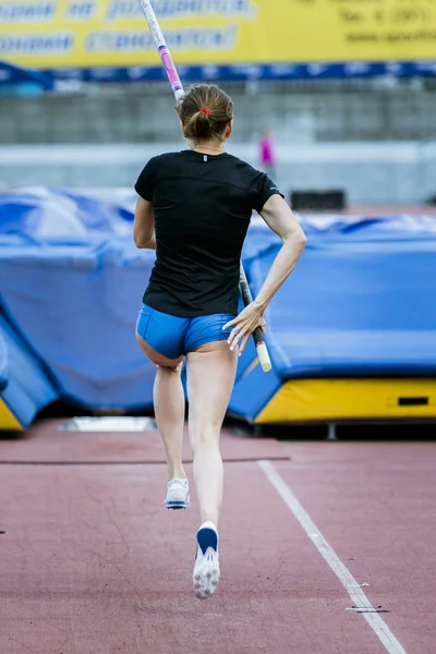 A female athlete competing in the pole vault