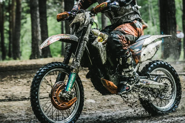Motocross driver on muddy offroad track