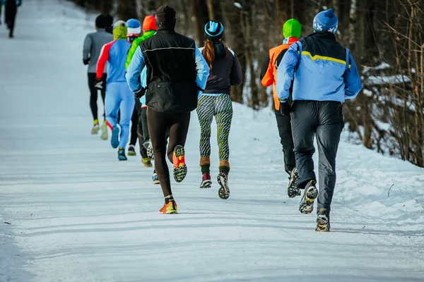 group of athletes running on winter alley