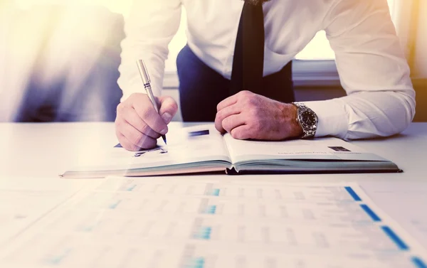 Businessman recording data on to schedule — Stock Photo, Image