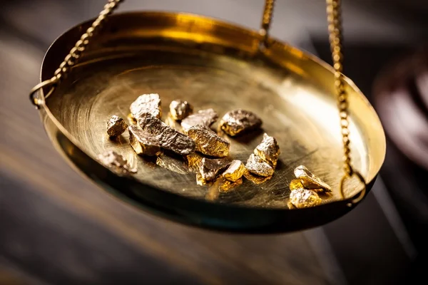 Small gold nuggets in measuring scale — Stock Photo, Image