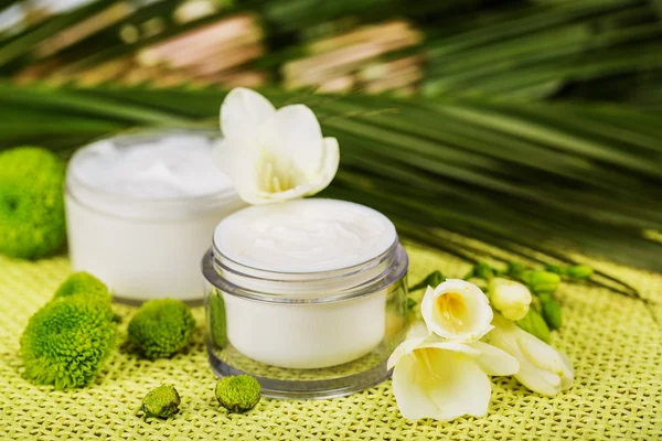 Cosmetische crème met witte bloemen — Stockfoto