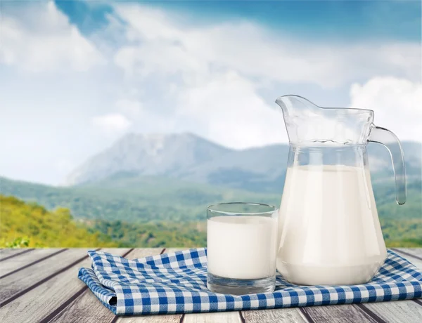 Glass of milk and jar — Stock Photo, Image