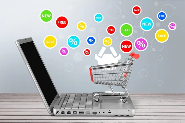 Shopping-cart over a laptop isolated — Stock Photo, Image