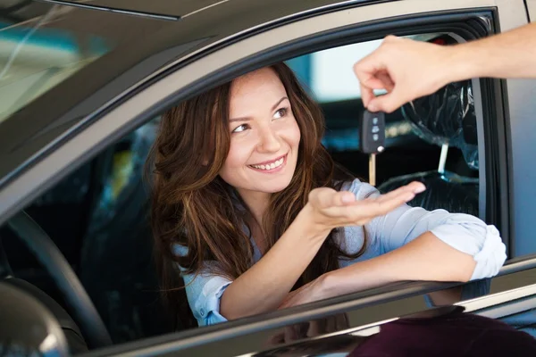 Woman taking keys while sitting at car — Stock Photo, Image