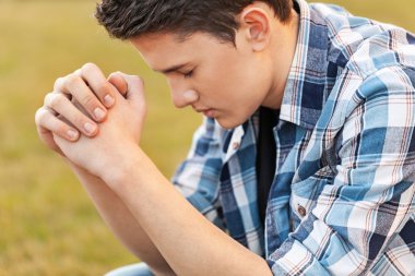 Handsome Young man  praying clipart
