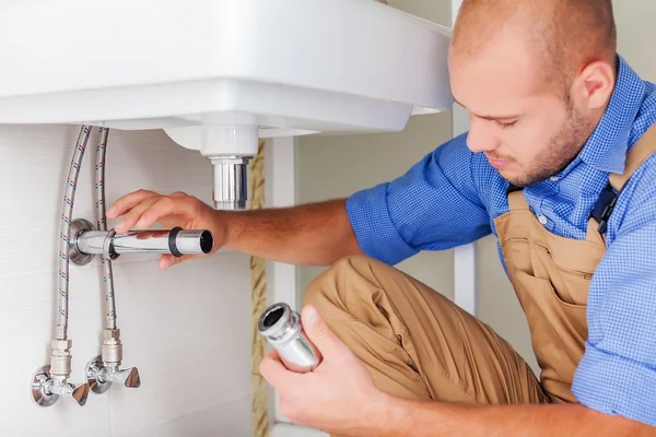 Professional plumber fixing pipes — Stock Photo, Image