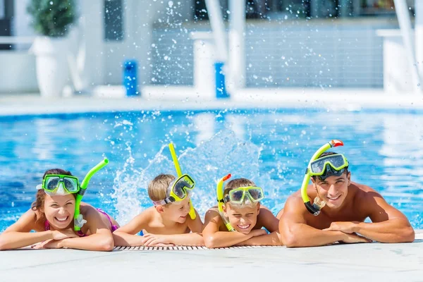 Familia feliz jugando en la piscina. — Foto de Stock