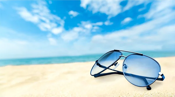 Sunglasses on sandy beach — Stock Photo, Image
