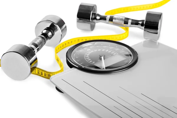 Dumbbells with measuring tape on  scales — Stock Photo, Image