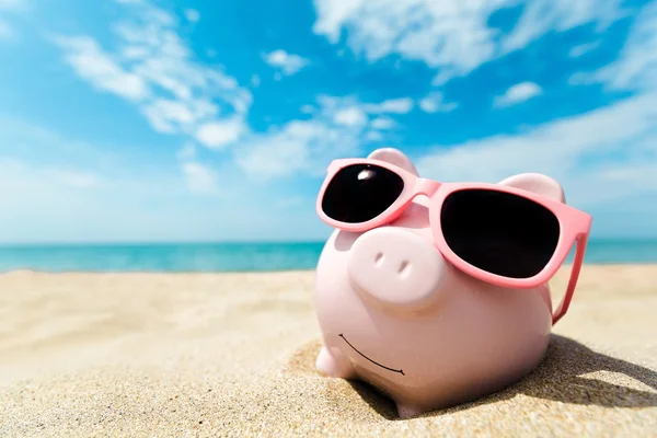 Piggy bank with sunglasses on the beach — Stock Photo, Image