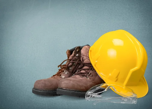 Yellow working hard hat, goggles and work boots — Stock Photo, Image