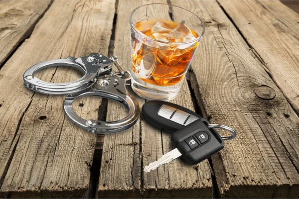 Whiskey met autosleutels en handboeien — Stockfoto