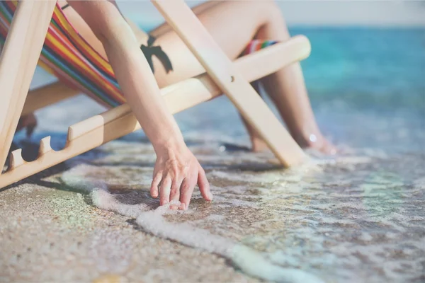 Vrouw aan het strand ontspannen op de stoel — Stockfoto