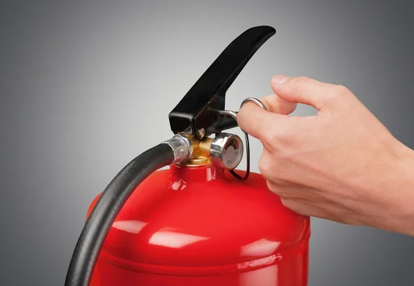 Mão pressiona o extintor de incêndio gatilho — Fotografia de Stock