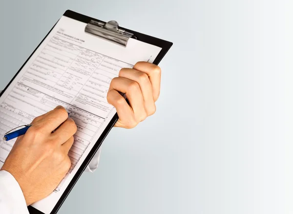 Ręce lekarza wypełnienie formularza — Zdjęcie stockowe