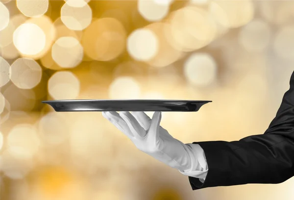 Waiter hand  holding an empty plate — Stock Photo, Image