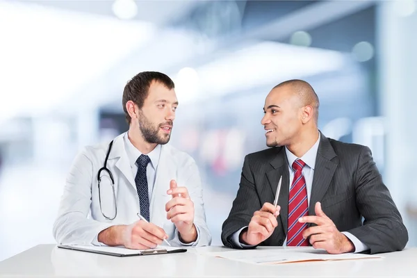 Homem de terno consultoria com médico — Fotografia de Stock