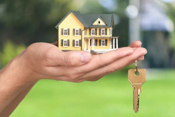 Empresário segurando modelo de casa — Fotografia de Stock