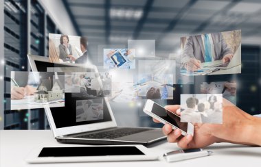 dizüstü bilgisayar yanında otururken Smartphone tutan el