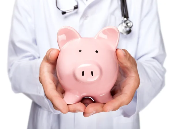 Medico con stetoscopio Holding Piggy Bank — Foto Stock