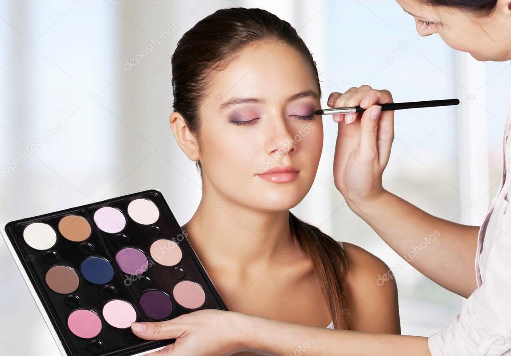 makeup artist doing makeup for girl 