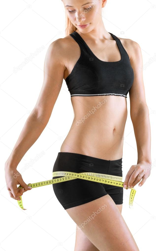 Young woman measuring her thin waist 