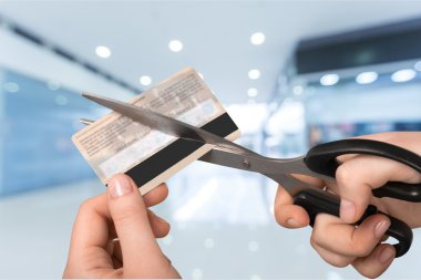hands cutting credit card with scissors clipart