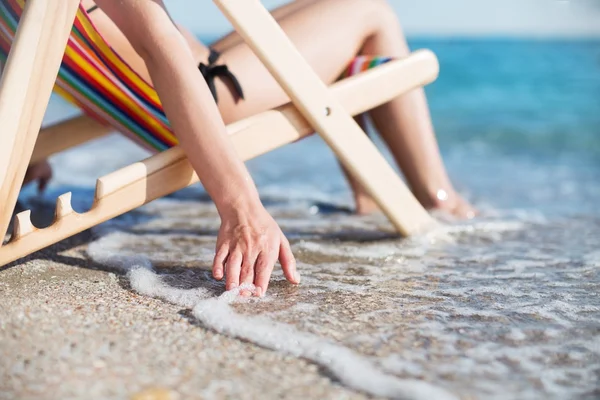 Mulher na praia relaxante na cadeira — Fotografia de Stock