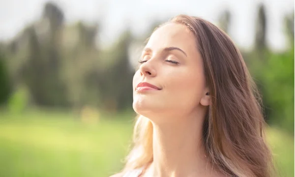 Vrouw op veld onder zonsondergang licht — Stockfoto