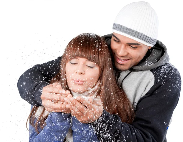 Счастливая молодая пара держит снежинки — стоковое фото