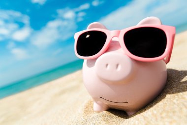 Sahilde güneş gözlüğü ile Piggy banka