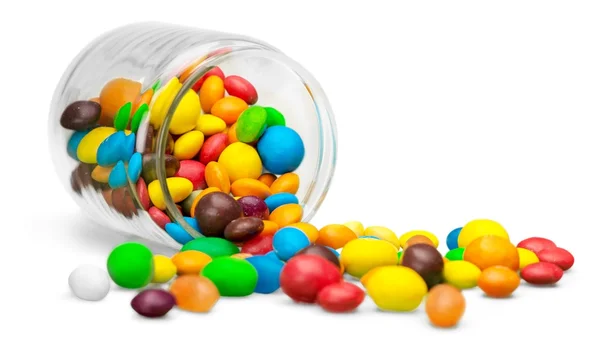 Bonbons colorés tombant d'un bocal en verre — Photo