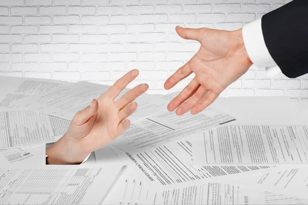 Businesswoman hand in stack of papers — Stock Photo, Image