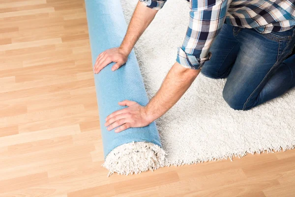 Male hands rolling carpet — Stock Photo, Image