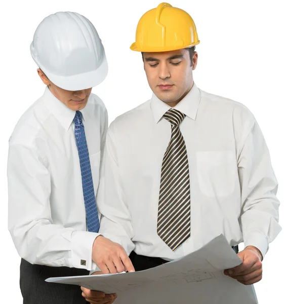 Businessmen in helmets looking at blueprint — Stock Photo, Image