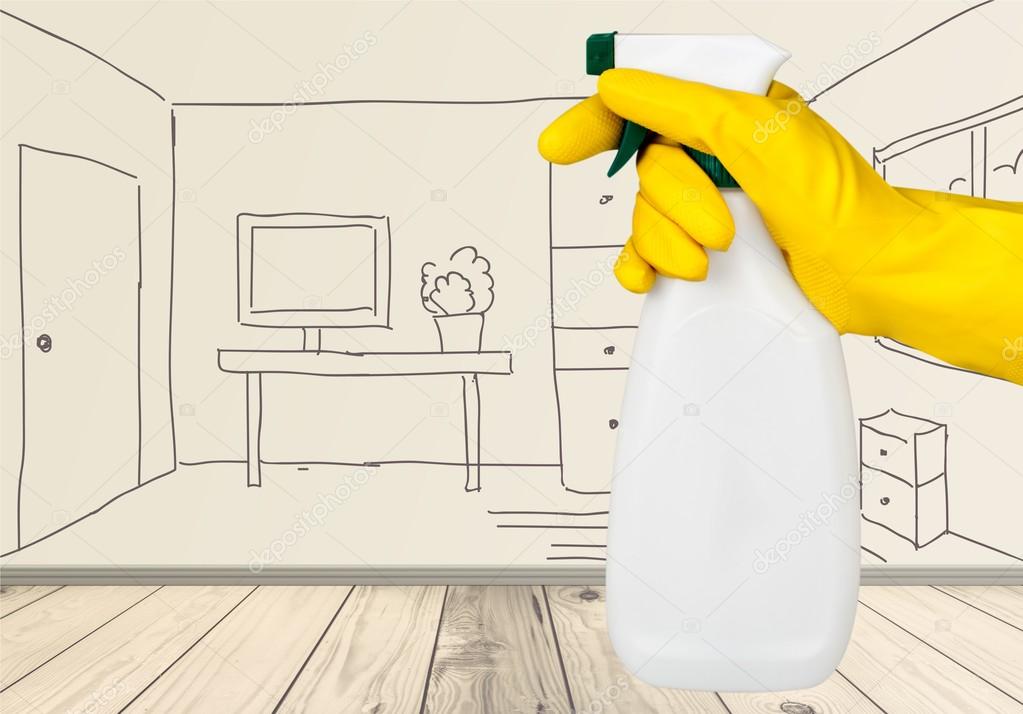 Hand in rubber glove holding spray bottle