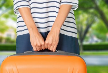 Seyahat çantası taşıyan genç bir kadın.