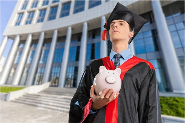 graduation man with piggy bank