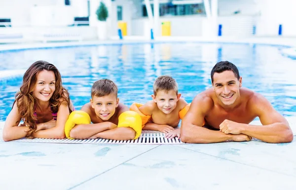 Famille heureuse jouant dans la piscine. — Photo